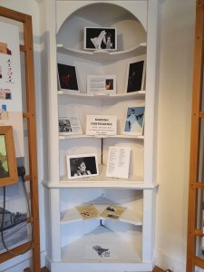 South Asian Heritage Month Exhibition at Headstone Manor and Museum - featuring a series of photographs and text in a white cupboard with multiple shelves. 